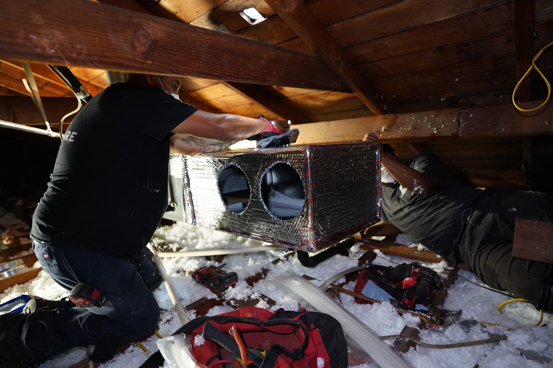 LA Air Care technicians installing an insulated supply plenum in an attic